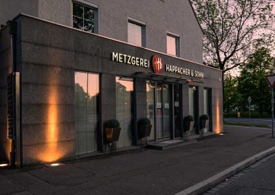 Leuchtbuchstaben vor Natursteinverkleidung