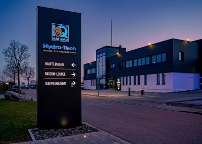Werbestele mit Wegeführung und beleuchtetem Logo