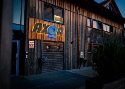 beleuchtetes Logo auf Holzfassade