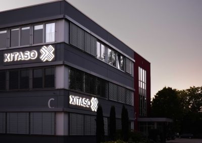 Beleuchtetes Logo am Bürogebäude